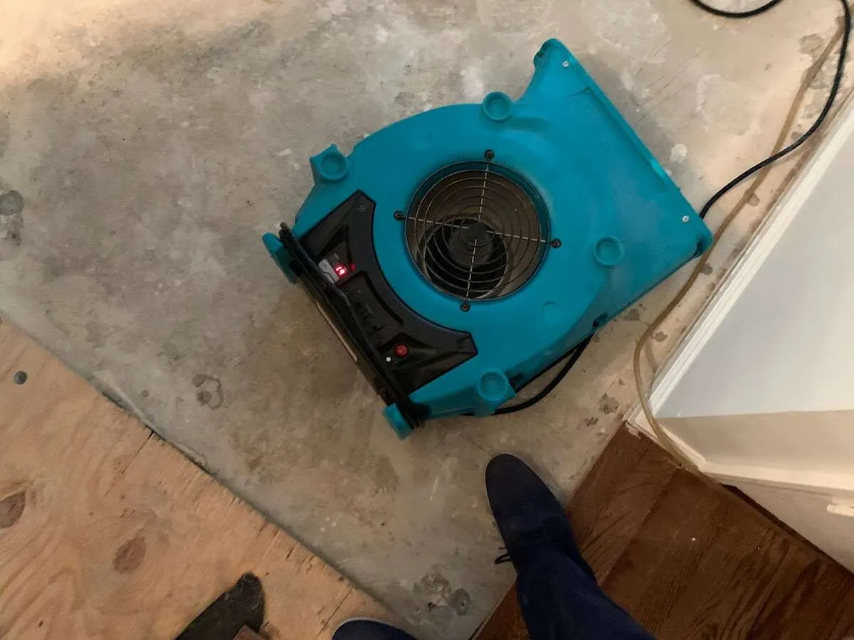 Air mover drying subfloor during Commercial Water Damage Restoration in Bartlett
